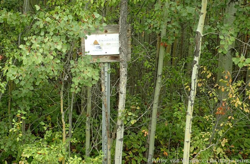A weather beaten sign indicating the southern border of Pigeon Lake NA along TWP RD 464.
